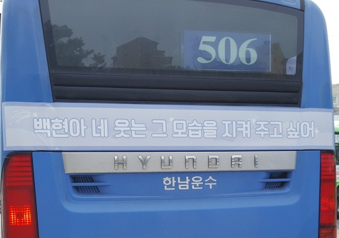 Rear of the bus with a pale blue strip carrying one line of Korean text in white