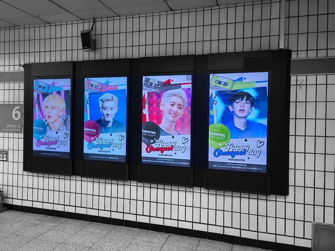 Chanyeol birthday ad on four upright digital screens on a subway station wall, each reading "Happy Chanyeol day"