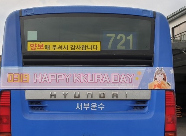 Rear of a blue Seoul city bus with a pink strip reading "0319 HAPPY KKURA DAY"