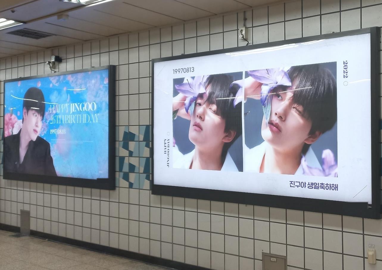 Two Yeo Jin-goo birthday ads side by side in subway lightboxes, a white panel with two photos and a blue panel reading "HAPPY JINGOO 26TH BIRTHDAY"